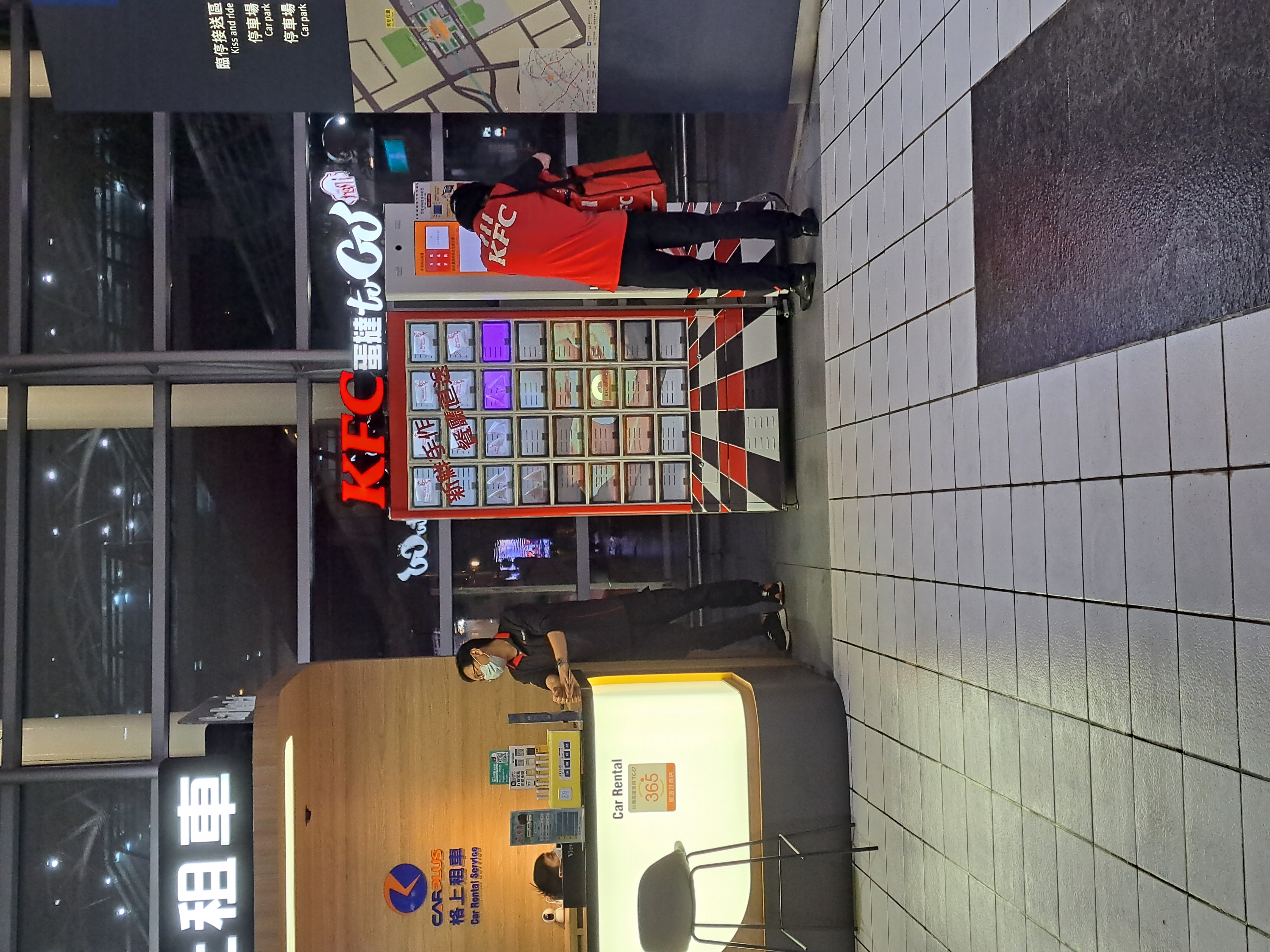 桃園高鐵站的肯德基品牌智慧販賣機，紅黑經典配色搭配多格取餐櫃設計