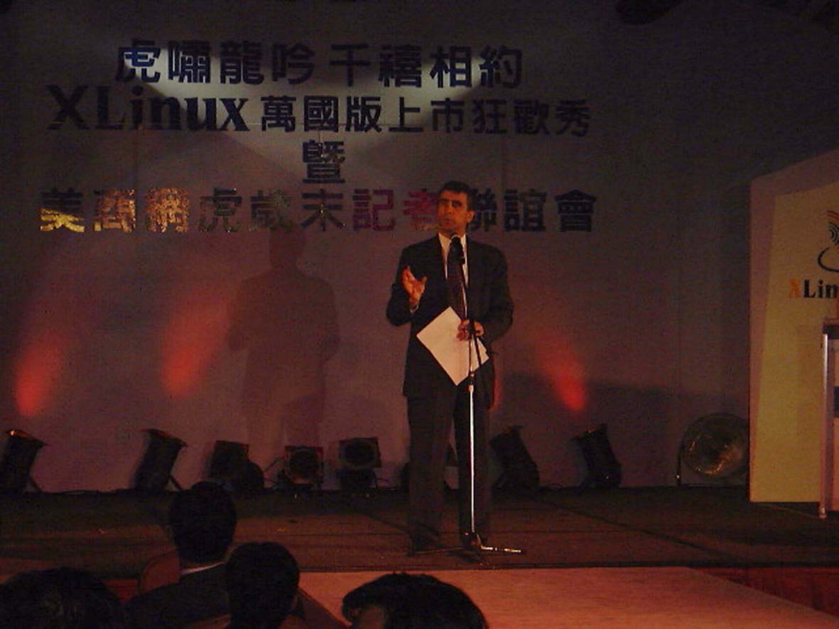 谷月涵（Peter Kurz）在 XLinux 萬國版上市發表會舞台致詞，背景可見 XLinux Inc. 標誌