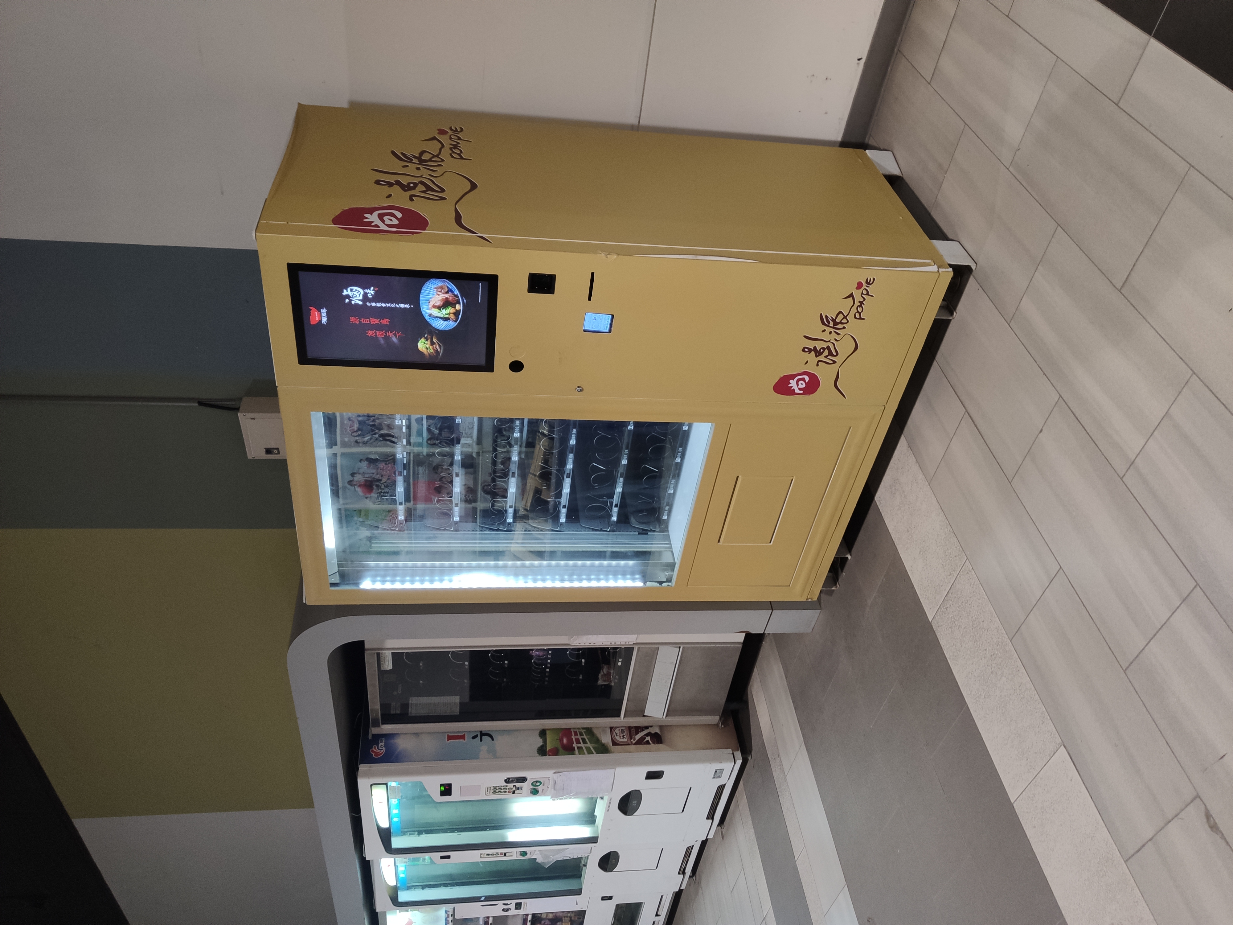 滷源品牌智慧販賣機（黃色機身）與丐幫滷味品牌機台並排部署於商業場域