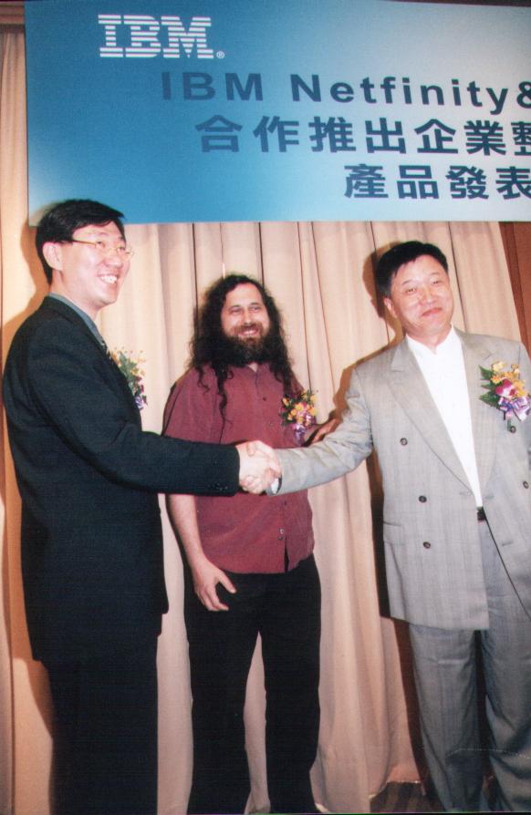 Richard Stallman 與李奇申、IBM 代表合影，背板為「IBM Netfinity＆網虎XLinux合作推出企業整體解決方案產品發表記者會」